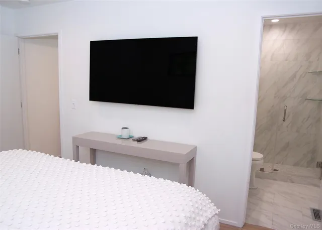 a bedroom with a bed and a flat screen tv