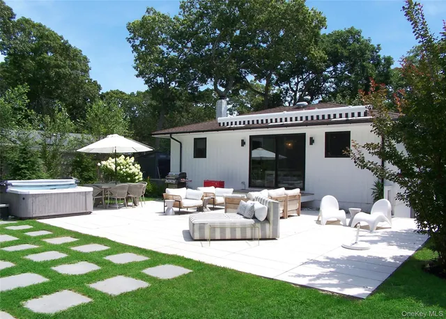 a view of a house with backyard and sitting area