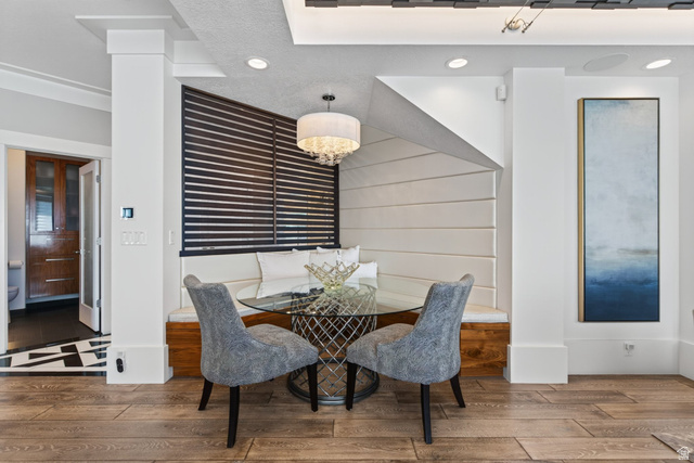 12308 Mariah Circle Draper, UT 84020 - Photo 35 of 293 Built-in dining nook featuring upholstered bench seating, a glass-top table, and wood-finish flooring