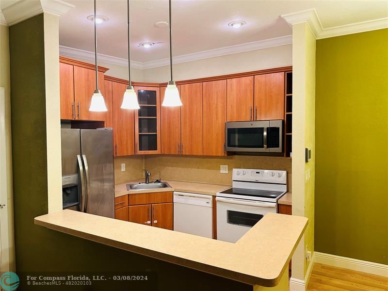 a kitchen with stainless steel appliances a sink a counter top space cabinets and a window