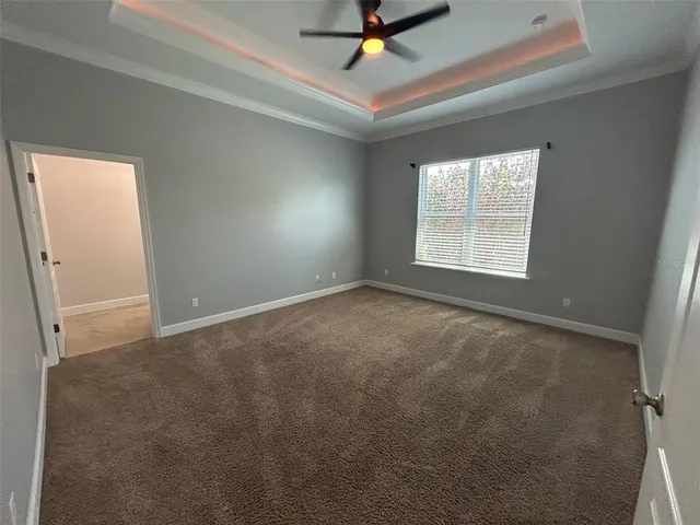 an empty room with a ceiling fan and windows