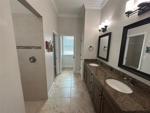 a bathroom with a granite countertop sink a mirror and a shower