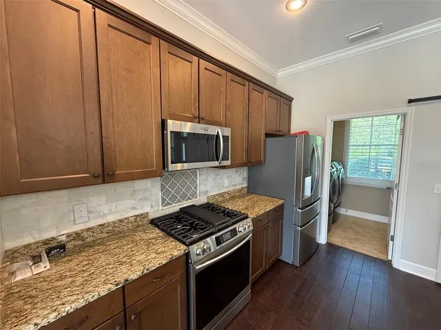 a kitchen with granite countertop a stove and a refrigerator
