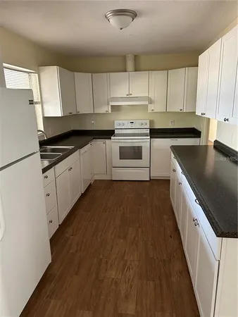 a kitchen with granite countertop a sink and cabinets