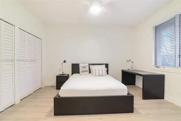 a bedroom with a bed and wooden floor