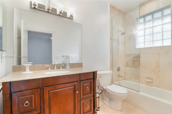 a bathroom with a sink a toilet a mirror and shower