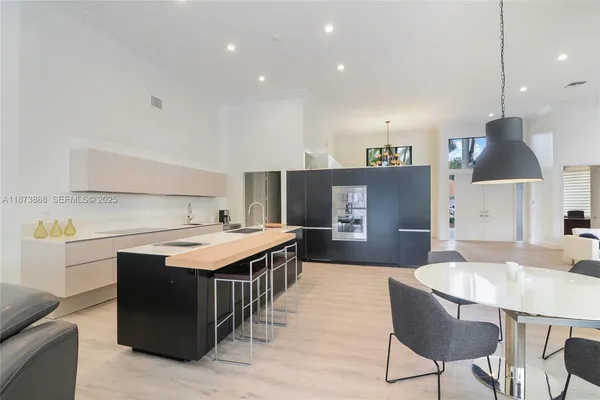 a kitchen with a stove a refrigerator a sink dishwasher with a dining table and chairs