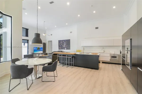 a large kitchen with kitchen island a large counter top space a sink stainless steel appliances and cabinets