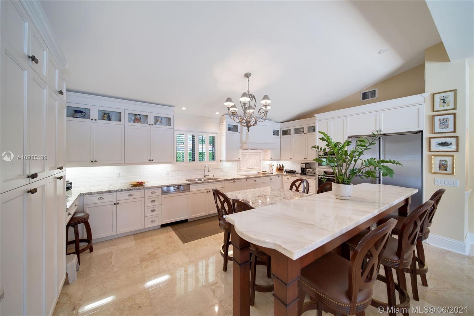 4804 Biltmore Drive Coral Gables, FL 33146 - Photo 11 of 47 a kitchen with a table chairs and white cabinets