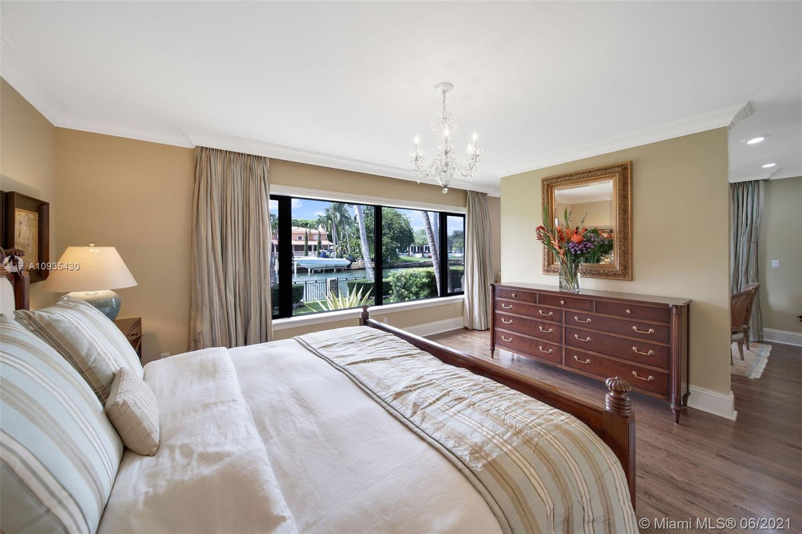 4804 Biltmore Drive Coral Gables, FL 33146 - Photo 29 of 47 a bedroom with a large bed and a chandelier