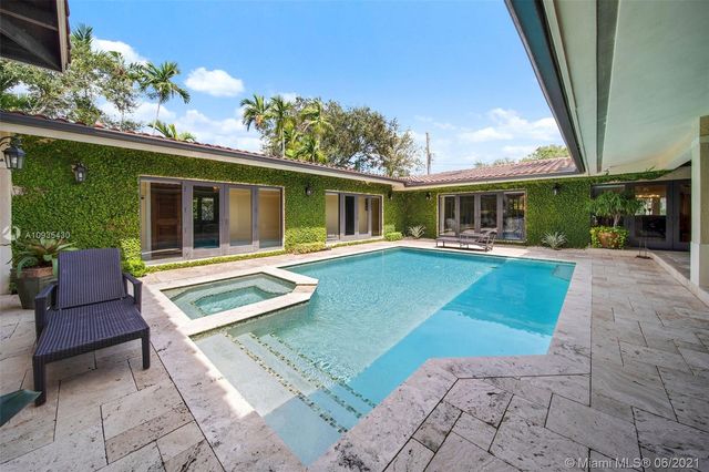 a view of a house with a backyard patio and swimming pool