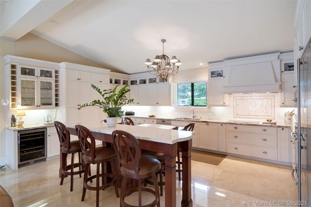 a kitchen with granite countertop a table and chairs in it