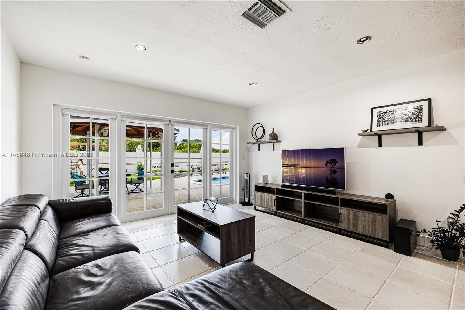 10520 Southwest 103rd Avenue Miami, FL 33176 - Photo 20 of 51 a living room with furniture and a flat screen tv