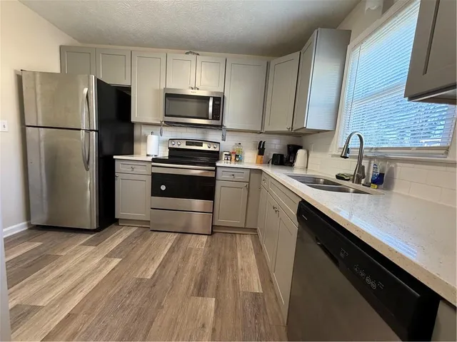 a kitchen with a sink a refrigerator and cabinets