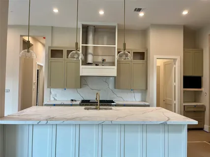 a kitchen with kitchen island a sink stainless steel appliances and cabinets