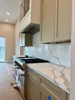 a kitchen with granite countertop a sink a stove and a microwave