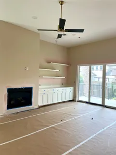 a view of an empty room with a fireplace and a window