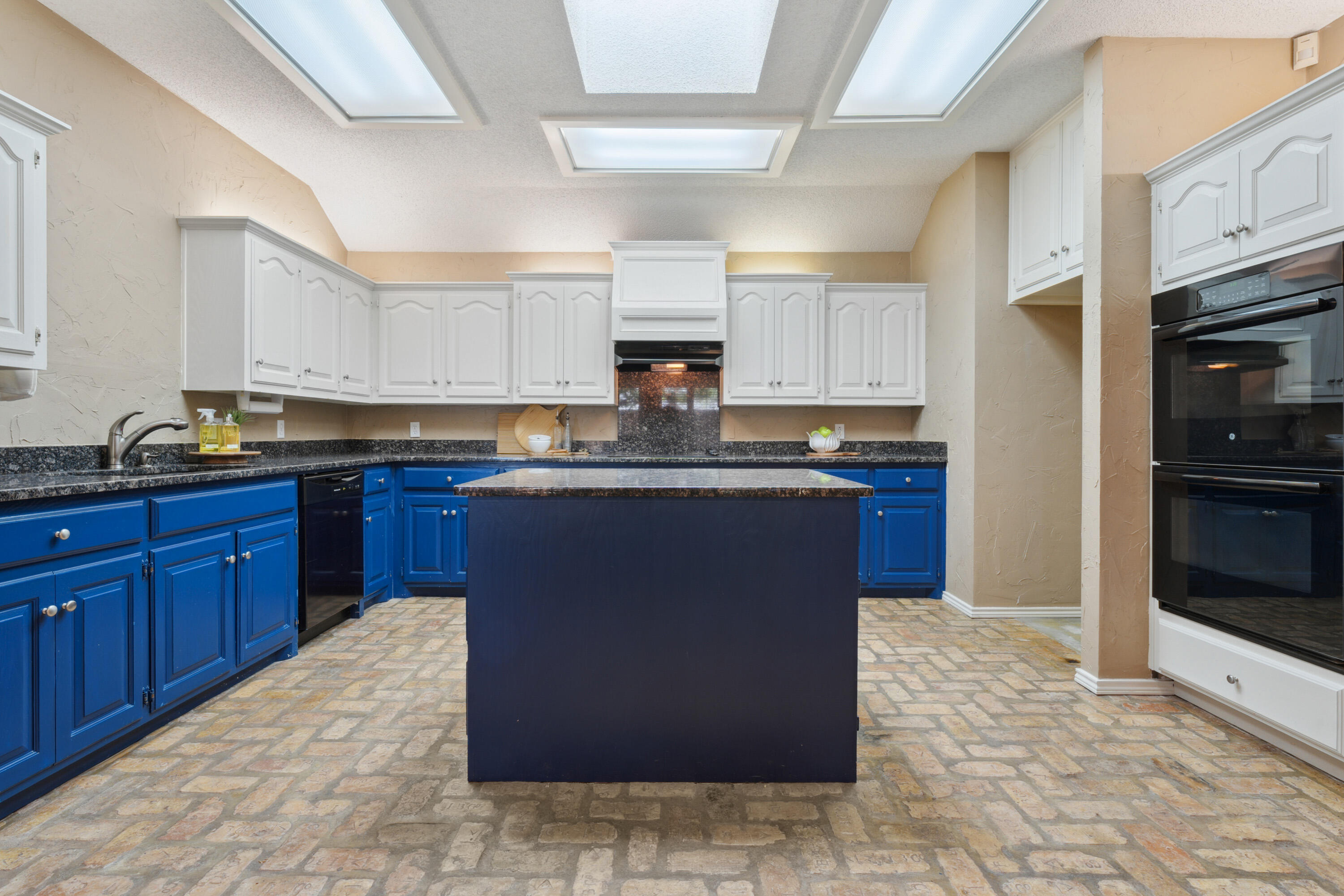 102 North Utica Avenue Lubbock, TX 79416 - Photo 17 of 36 a kitchen with kitchen island granite countertop a sink a counter top space and cabinets