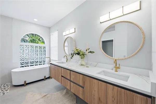 a bathroom with a double vanity sink mirror and bathtub
