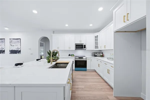 a kitchen with kitchen island granite countertop a sink stainless steel appliances and cabinets