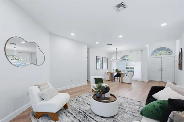 a living room with furniture a rug and a mirror