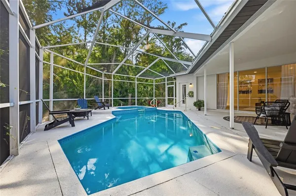 a view of a swimming pool with a patio and couches chairs
