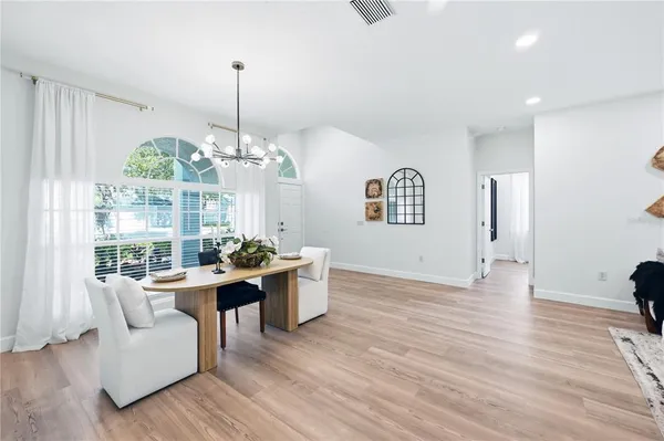 a living room with furniture a chandelier and a large window