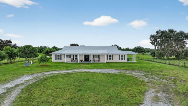 a view of a house with backyard porch and sitting area