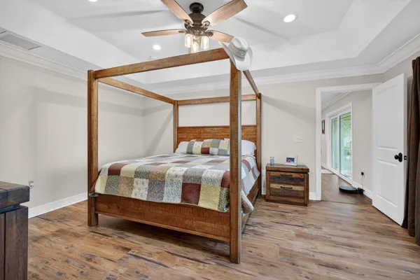 a bedroom with a bed a chandelier and a flat tv screen