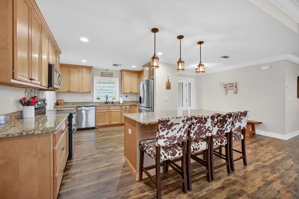 a kitchen with stainless steel appliances granite countertop a refrigerator stove and sink