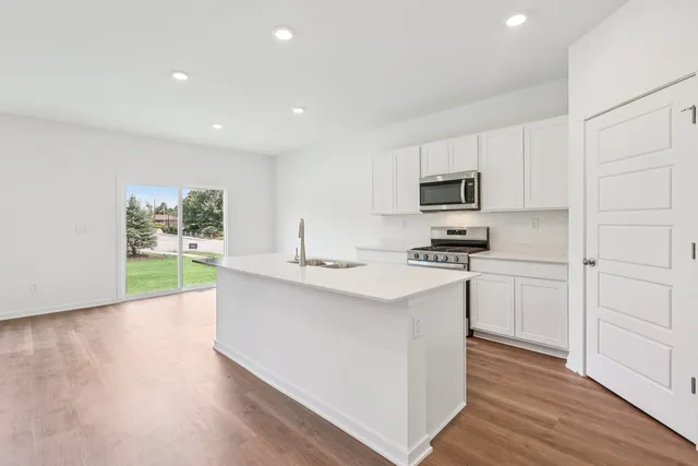 a kitchen with sink a microwave and cabinets