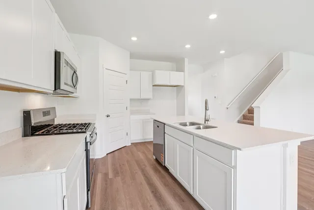 a kitchen with a sink a stove and cabinets
