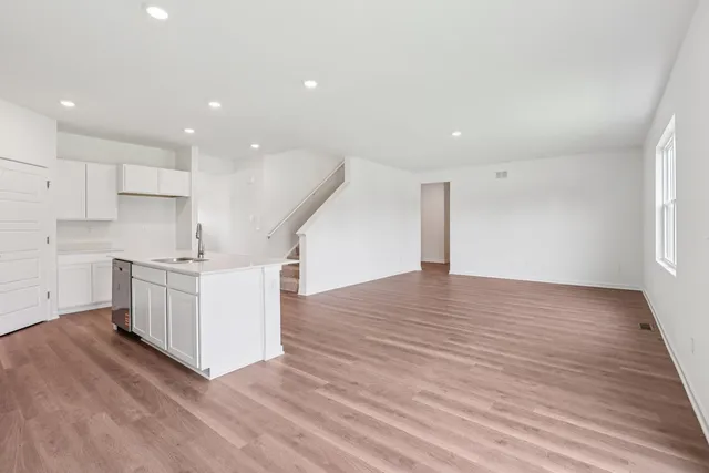 a view of kitchen with granite countertop white cabinets and stainless steel appliances