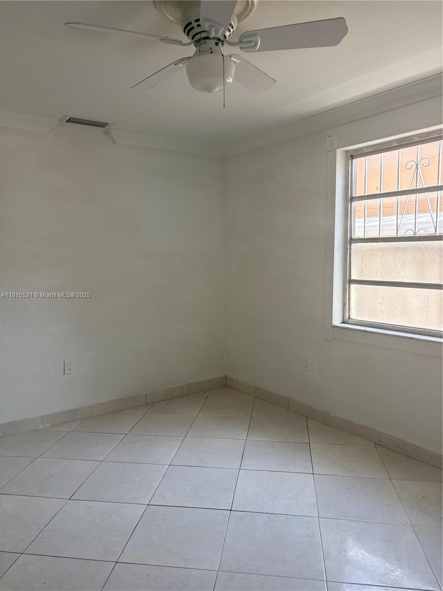 927 Southwest 9th Avenue, Unit 1 Miami, FL 33130 - Photo 2 of 16 an empty room with a ceiling fan and window