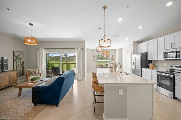 a large kitchen with kitchen island a large counter top space appliances and cabinets