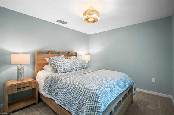 a bedroom with a bed and a lamp
