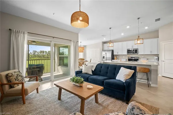 a living room with furniture kitchen and a large window
