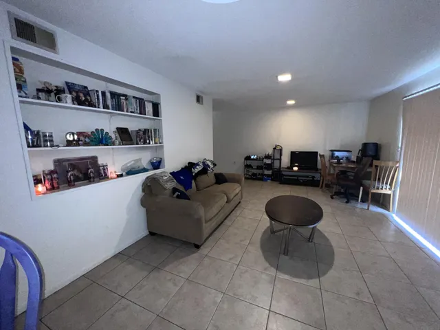 a living room with furniture and a book shelf