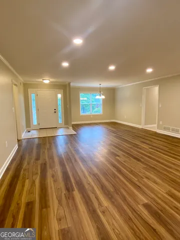 a view of an empty room with wooden floor