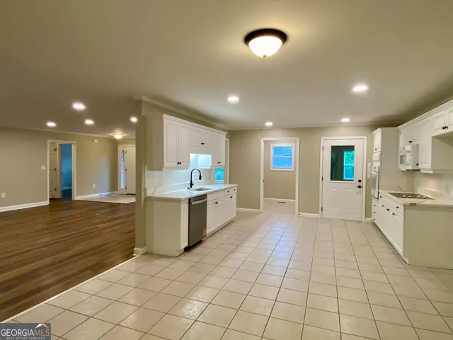a view of a kitchen with kitchen island granite countertop a window and a sink