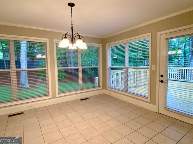a view of empty room with wooden floor and windows