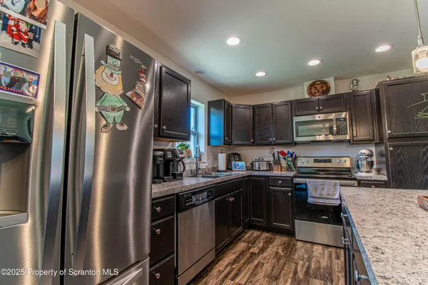 a kitchen with stainless steel appliances granite countertop refrigerator a sink a stove top oven and a refrigerator