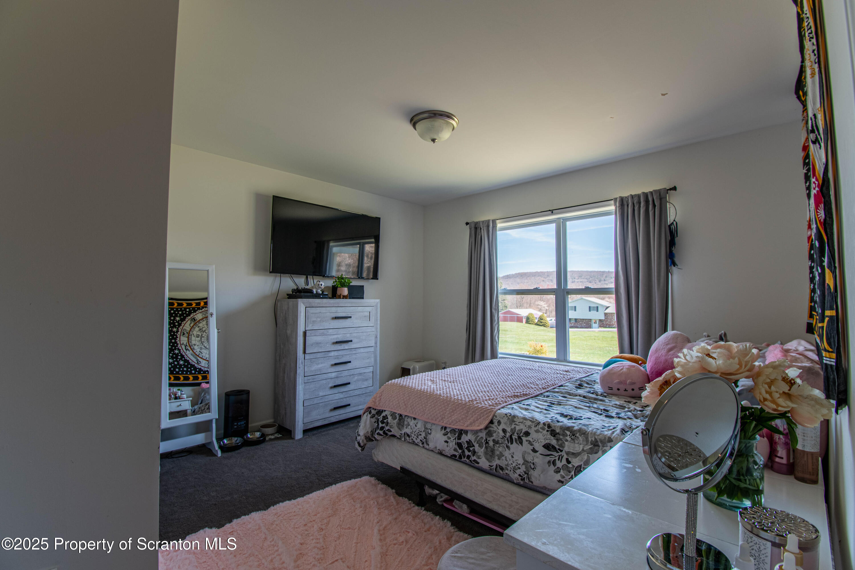 151 Sandy Banks Road Carbondale, PA 18407 - Photo 13 of 36 a bedroom with a bed and a flat screen tv
