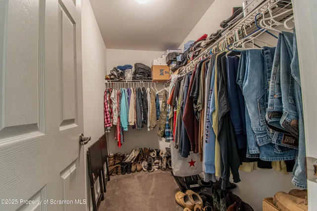 a view of walk in closet with clothes