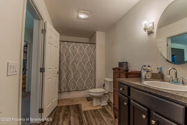 a bathroom with a granite countertop sink toilet and shower curtains