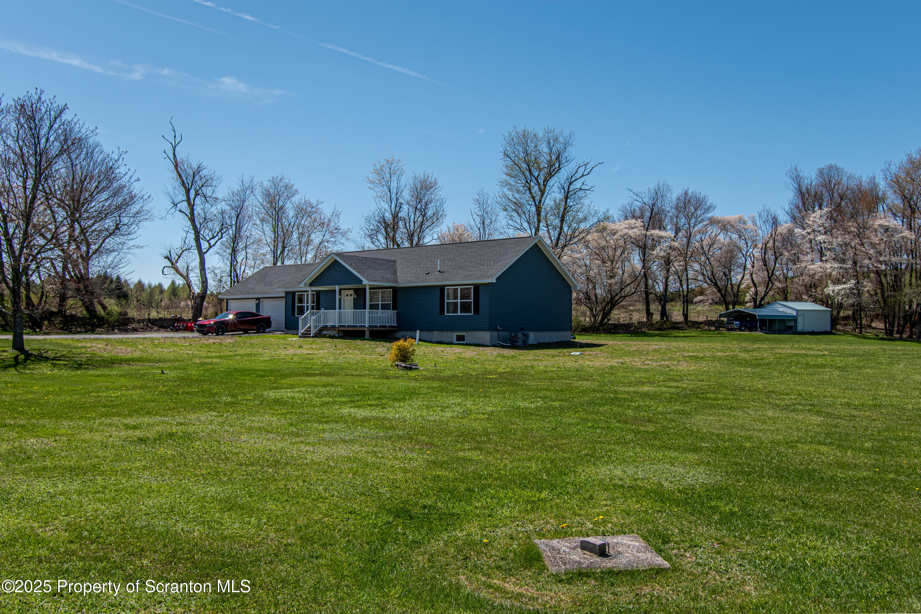 151 Sandy Banks Road Carbondale, PA 18407 - Photo 35 of 36 a front view of a house with a garden and trees