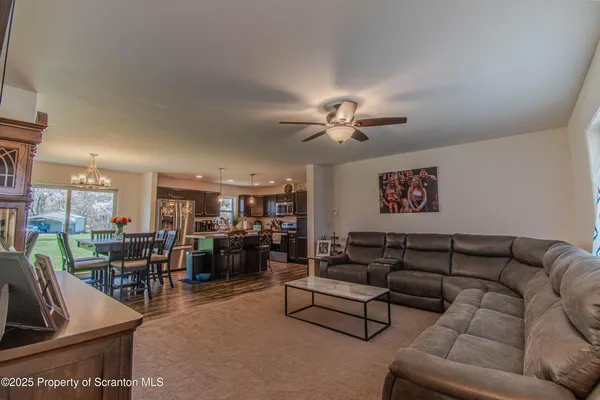 a living room with furniture kitchen view and a large window