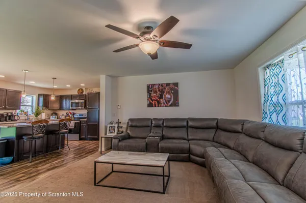 a living room with furniture kitchen view and a chandelier