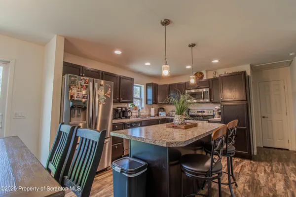 a view of a dining room with furniture a kitchen and chandelier