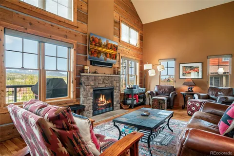 a living room with furniture fireplace and a large window